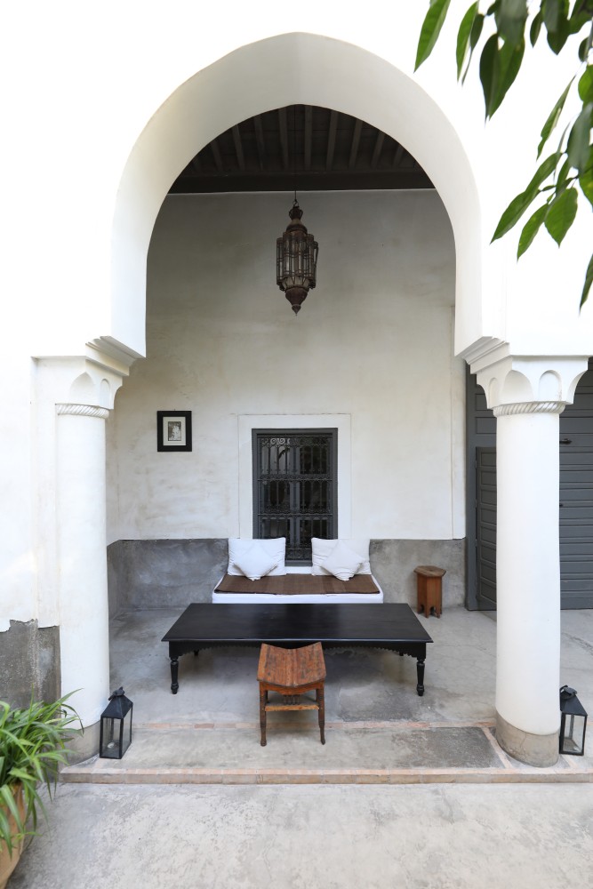 The garden bhou — a banquette beneath the arch, lantern lit