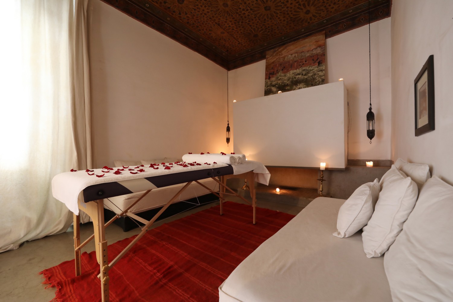 The massage room beneath its painted ceiling: rose petals, lanterns and candles