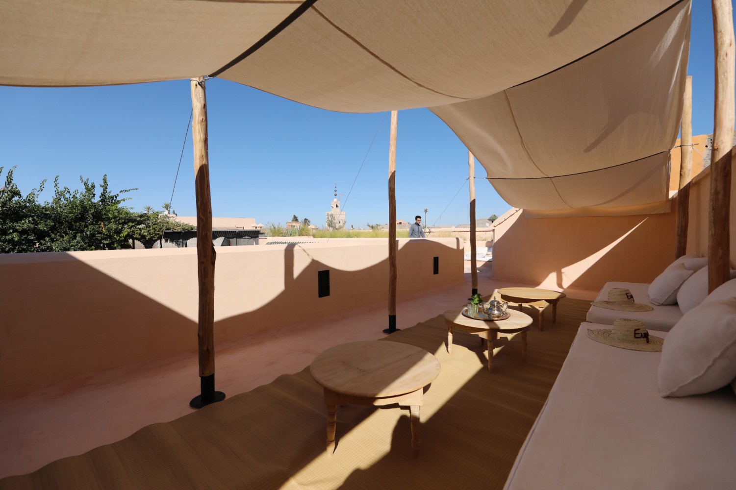 The rooftop lounge under its shade sails, teapot and fresh mint on the low table, a minaret in the distance